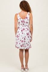 woman wearing a white floral sundress with a fitted waist and a flared skirt, viewed from the back