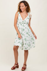 woman wearing a white floral print dress with tie straps and a flattering v-neckline