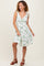 woman wearing a white floral print dress with tie straps and a flattering v-neckline