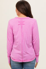 woman wearing a pink long sleeve maternity top with a crisscross back design and casual style