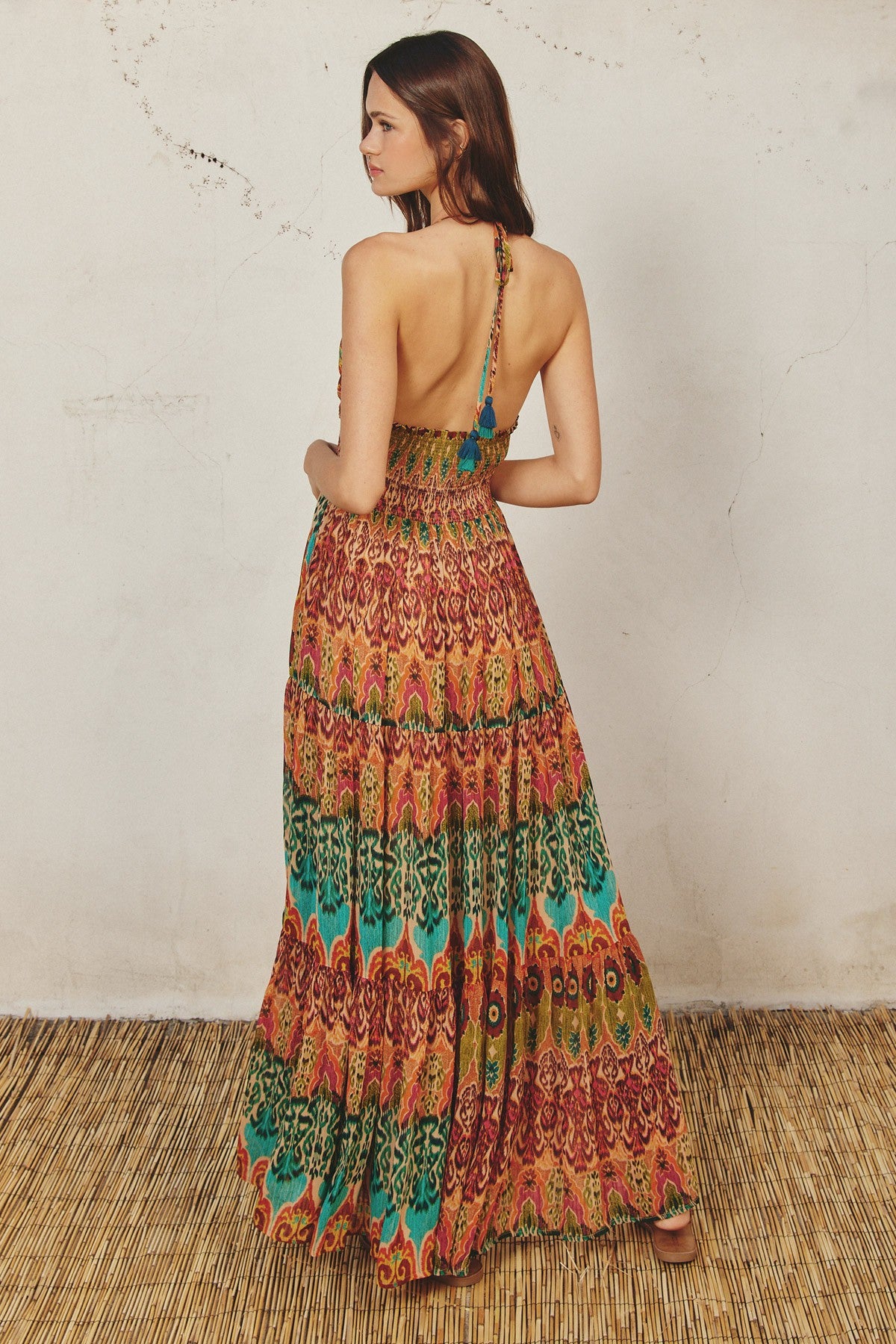woman wearing a colorful backless maxi dress with a tribal pattern and halter neck detail