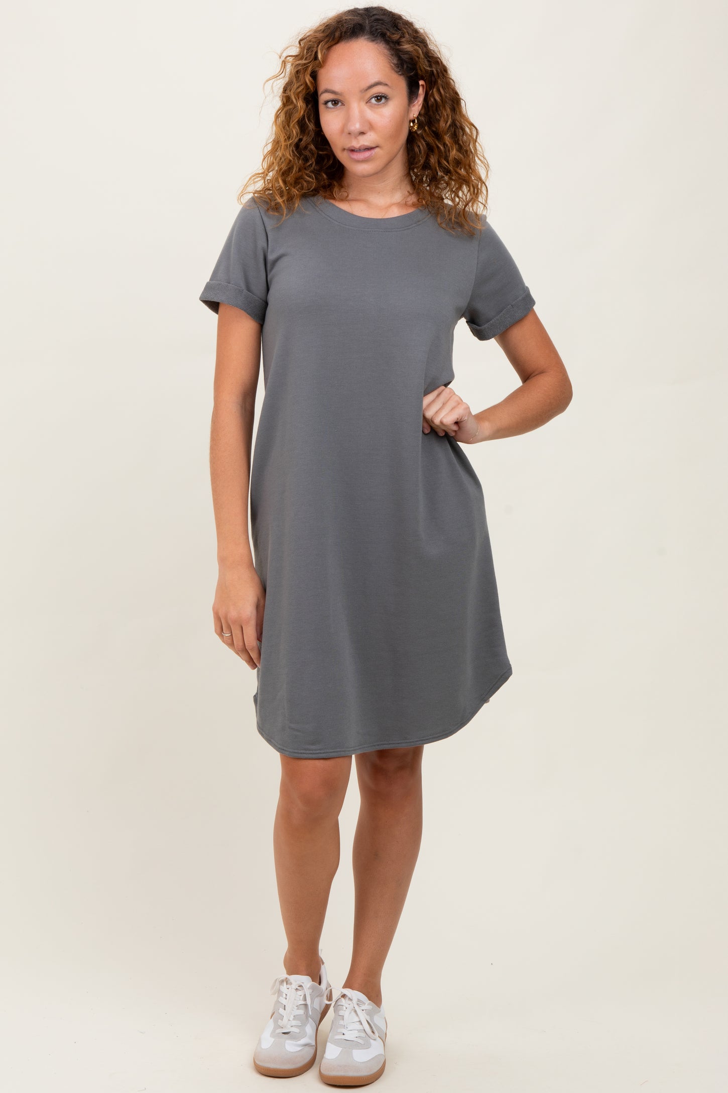 woman wearing a gray short sleeve dress with a pocket and styled with white sneakers