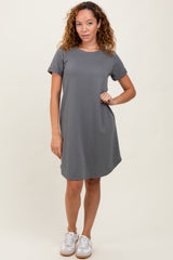 woman wearing a gray short sleeve dress with a pocket and styled with white sneakers