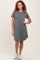 woman wearing a gray short sleeve dress with a pocket and styled with white sneakers