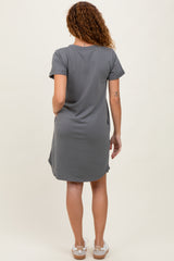 woman wearing a gray short sleeve dress with a relaxed fit and side pockets, viewed from the back