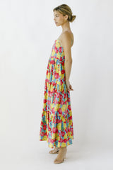 woman wearing a floral maxi dress with tiers in vibrant colors and spaghetti straps