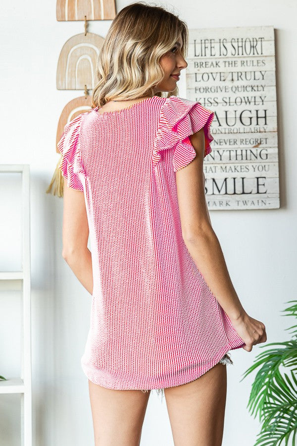 woman wearing a pink and white striped top with ruffle sleeves, shown from the back
