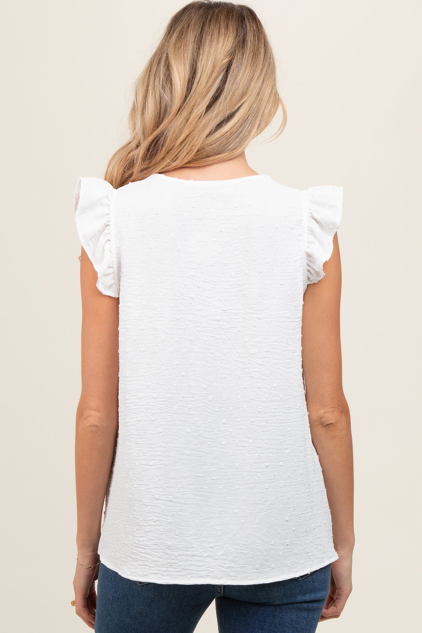 woman wearing a white maternity top with ruffled sleeves, shown from the back