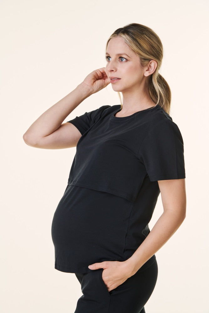 woman wearing a black maternity top with a layered design and visible baby bump