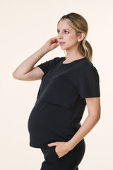 woman wearing a black maternity top with a layered design and visible baby bump