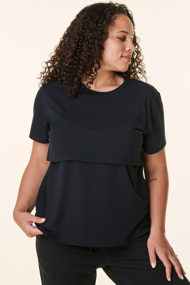 woman wearing a black short sleeve layered top with a relaxed fit and round neckline
