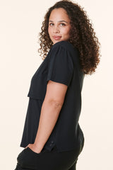 woman wearing a black short sleeve top with a layered design and relaxed fit