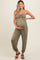 woman wearing an olive green strapless maternity jumpsuit and holding her baby bump
