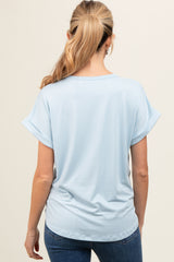 woman wearing a light blue short sleeve maternity top, viewed from the back, paired with dark jeans