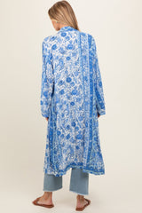 woman wearing a long blue floral maternity kimono over casual jeans and sandals, showing a relaxed fit and elegant design