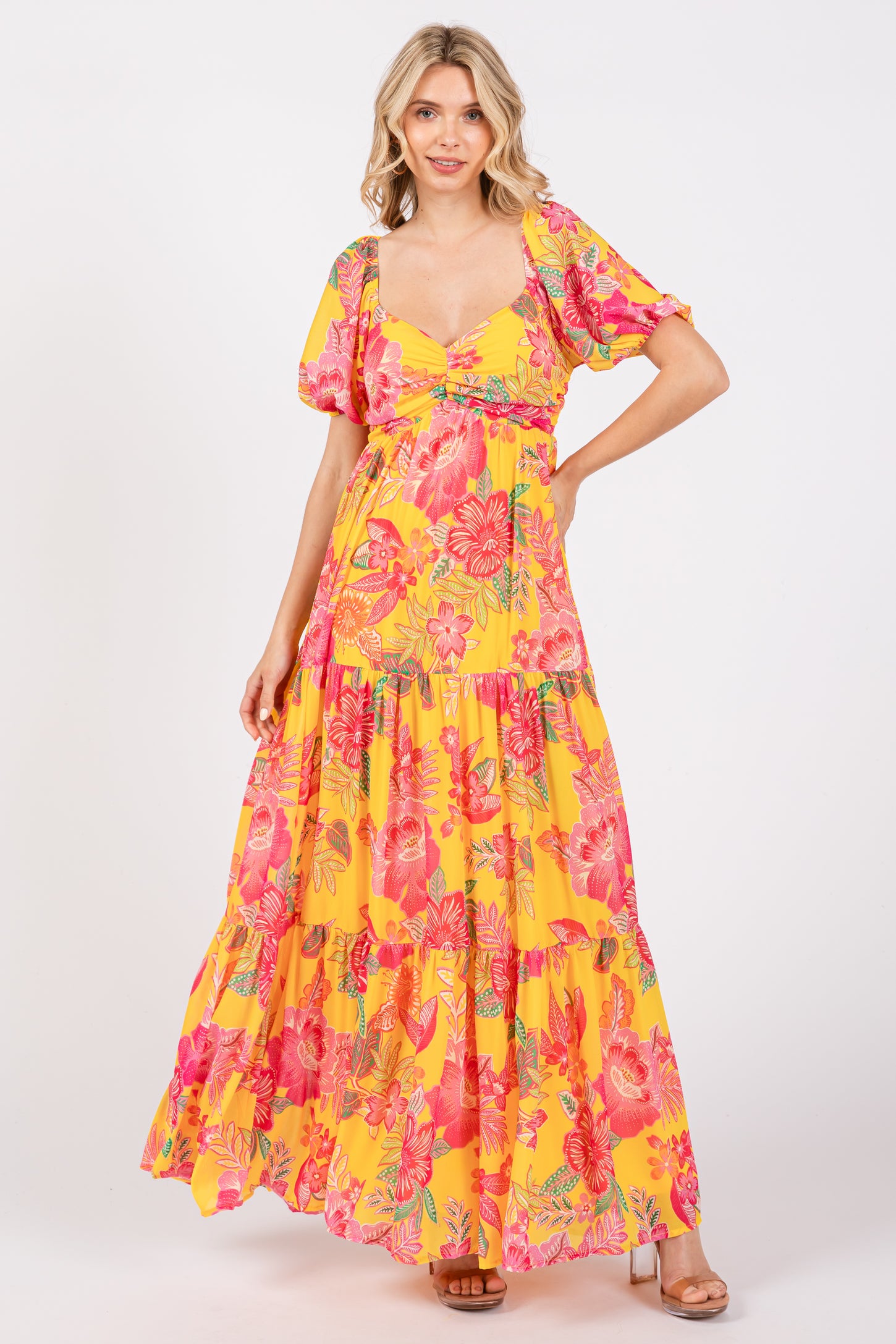 woman wearing a yellow floral maxi dress with puff sleeves and a tiered skirt