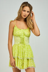 woman wearing a lime green tiered mini dress with spaghetti straps and lace trim details