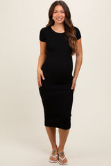 woman wearing a black ribbed short sleeve maternity dress and showing her baby bump