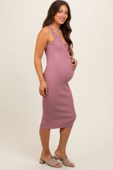 woman wearing a dark mauve ribbed maternity dress, showcasing her baby bump, paired with light beige mules