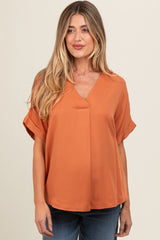 woman wearing an orange v-neck maternity top with short sleeves and a relaxed fit
