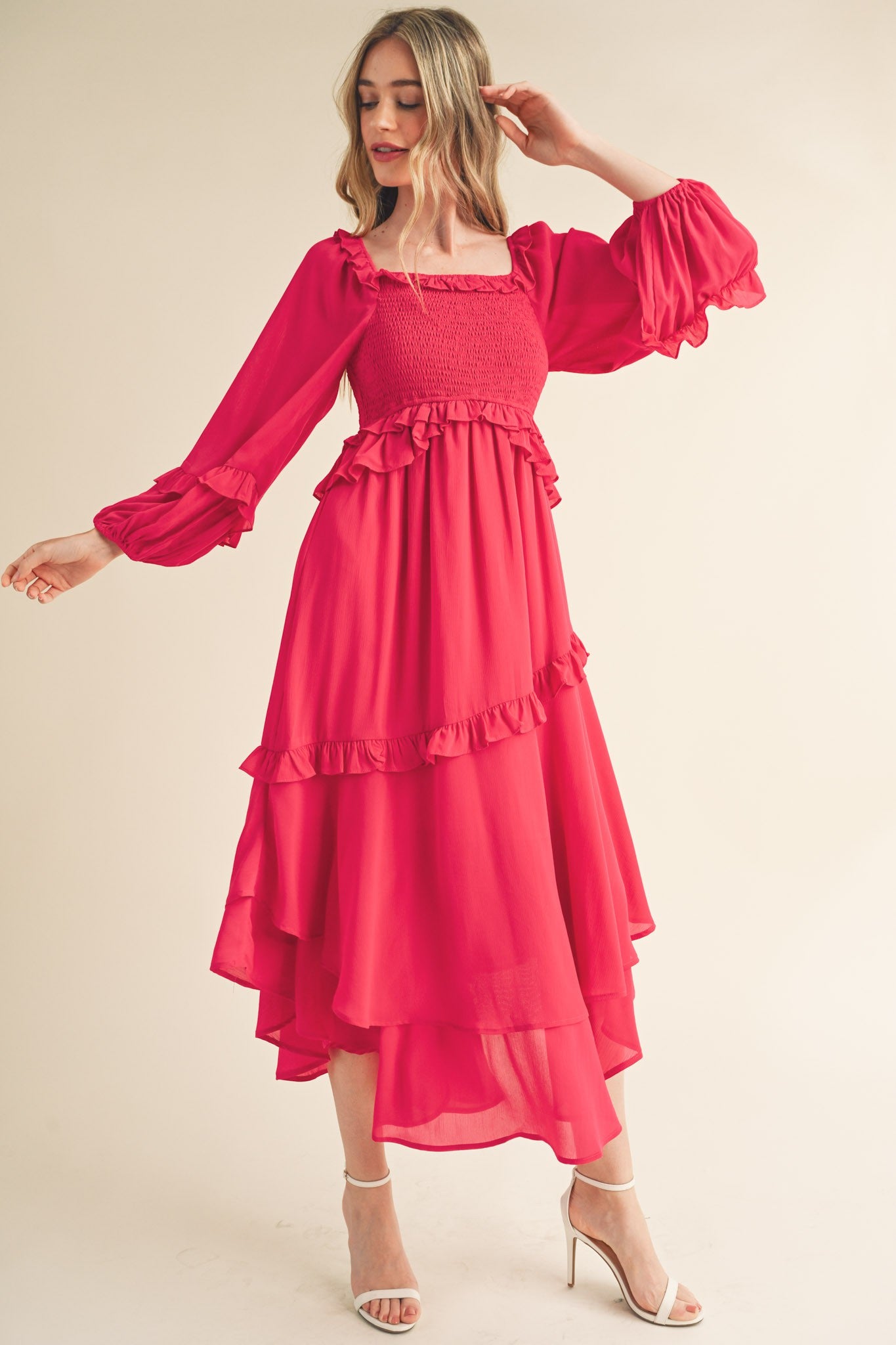 woman wearing a bright pink tiered midi dress with puffed sleeves and ruffle details