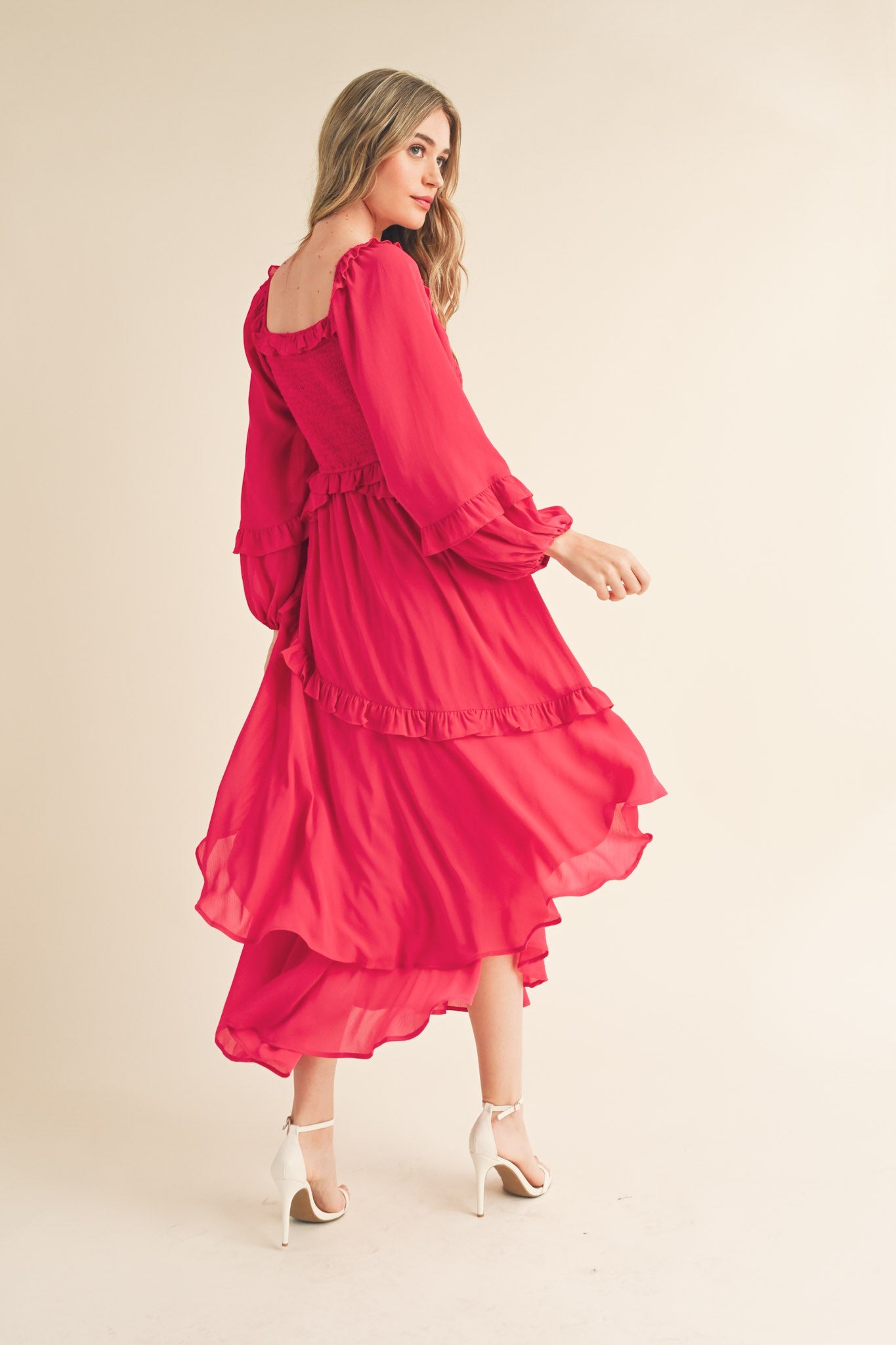 woman wearing a bright red long sleeve tiered maxi dress with ruffles and a flowy skirt