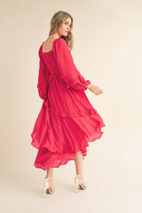 woman wearing a bright red long sleeve tiered maxi dress with ruffles and a flowy skirt