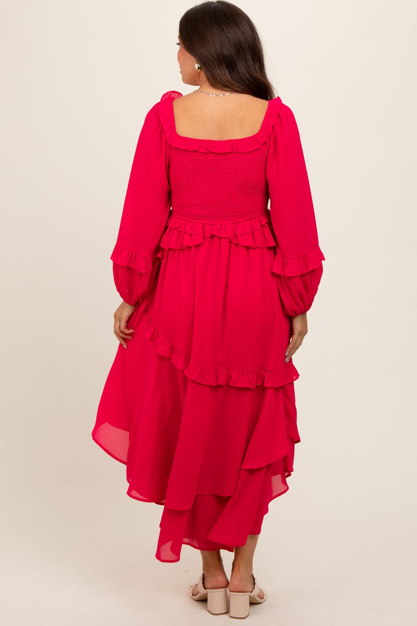 maternity wear in vibrant pink with ruffled layers and long sleeves, model shown from the back
