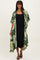 woman wearing a green leaf patterned kimono over a black midi dress and black strappy sandals