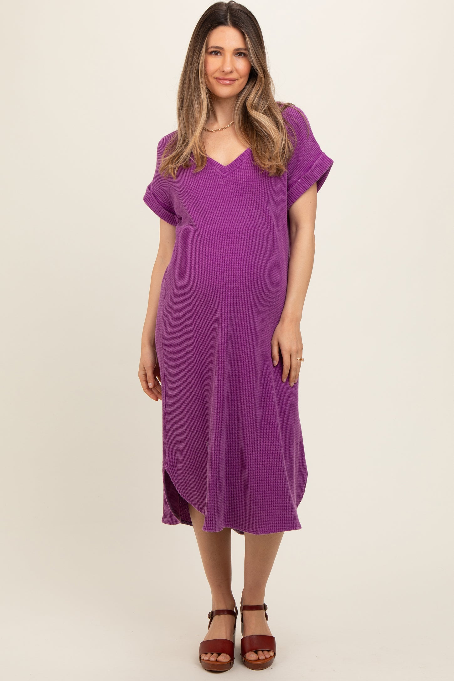 woman wearing a purple maternity dress with a v-neck and short sleeves, showing off her baby bump