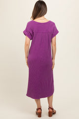 woman wearing a purple maternity dress with short rolled sleeves and a relaxed fit, showing a baby bump from behind