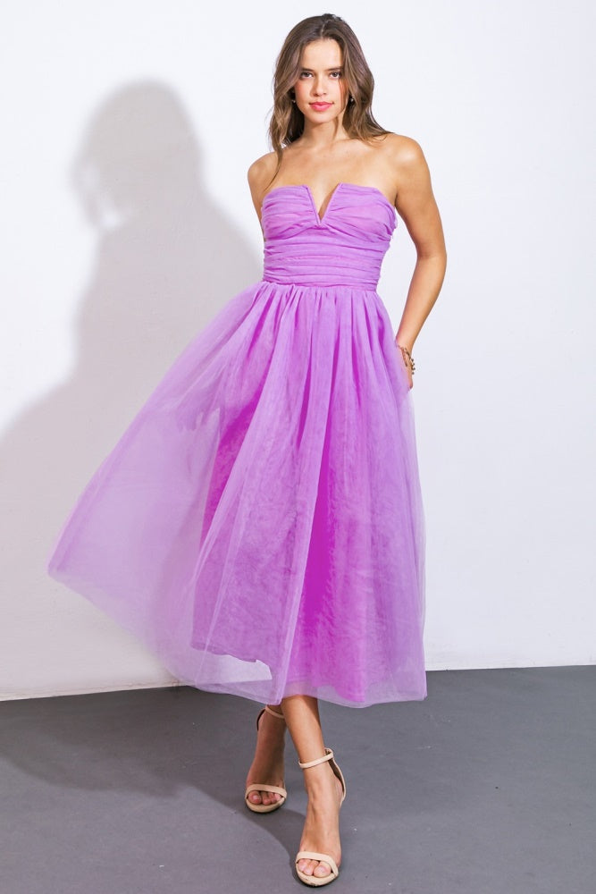 woman wearing a strapless lavender midi dress with a fitted bodice and flowing tulle skirt