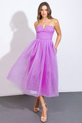 woman wearing a strapless lavender midi dress with a fitted bodice and flowing tulle skirt