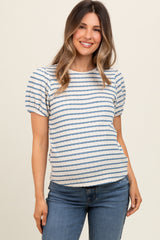 woman wearing a striped short sleeve maternity top with a relaxed fit and smiling while standing in front of a neutral background