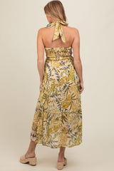woman wearing a floral print strapless maternity maxi dress with a halter tie and smocked bodice, view from the back