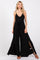 woman wearing a black sleeveless jumpsuit with a deep v-neck and side slits, tied at the waist