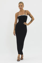 woman wearing a black sleeveless maxi dress with a drawstring detail and decorative straps