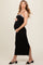 woman wearing a black maternity maxi dress with a strappy design and holding her baby bump