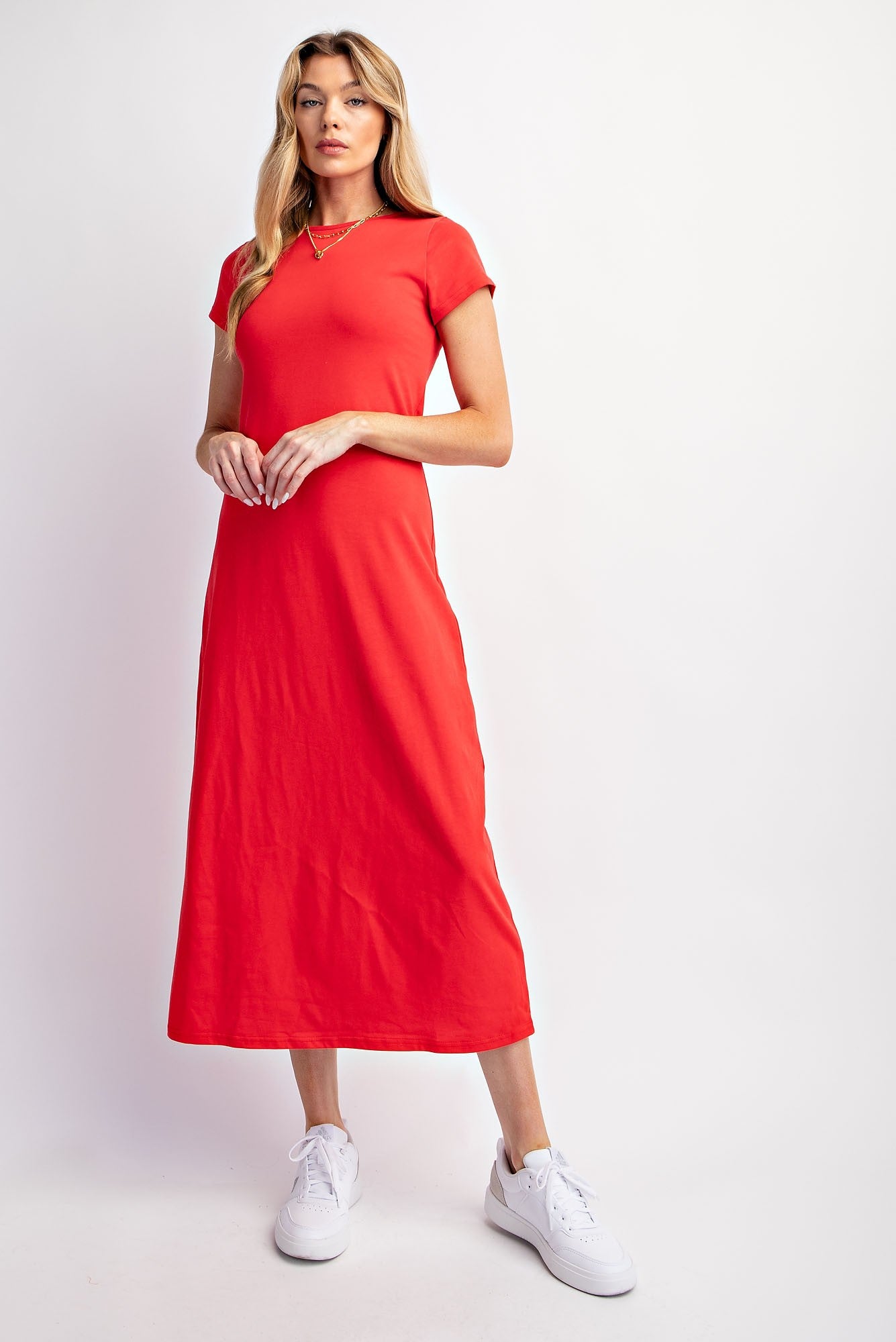 woman wearing a red short sleeve maxi dress paired with white sneakers