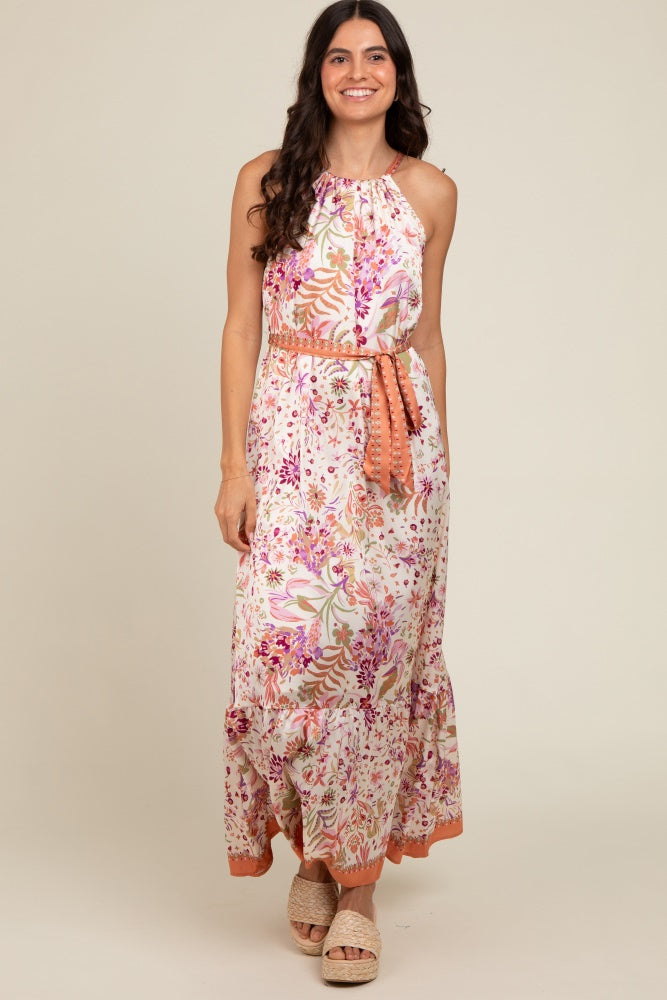 woman wearing a floral maxi dress with a halter neckline and side tie, featuring pink and orange accents