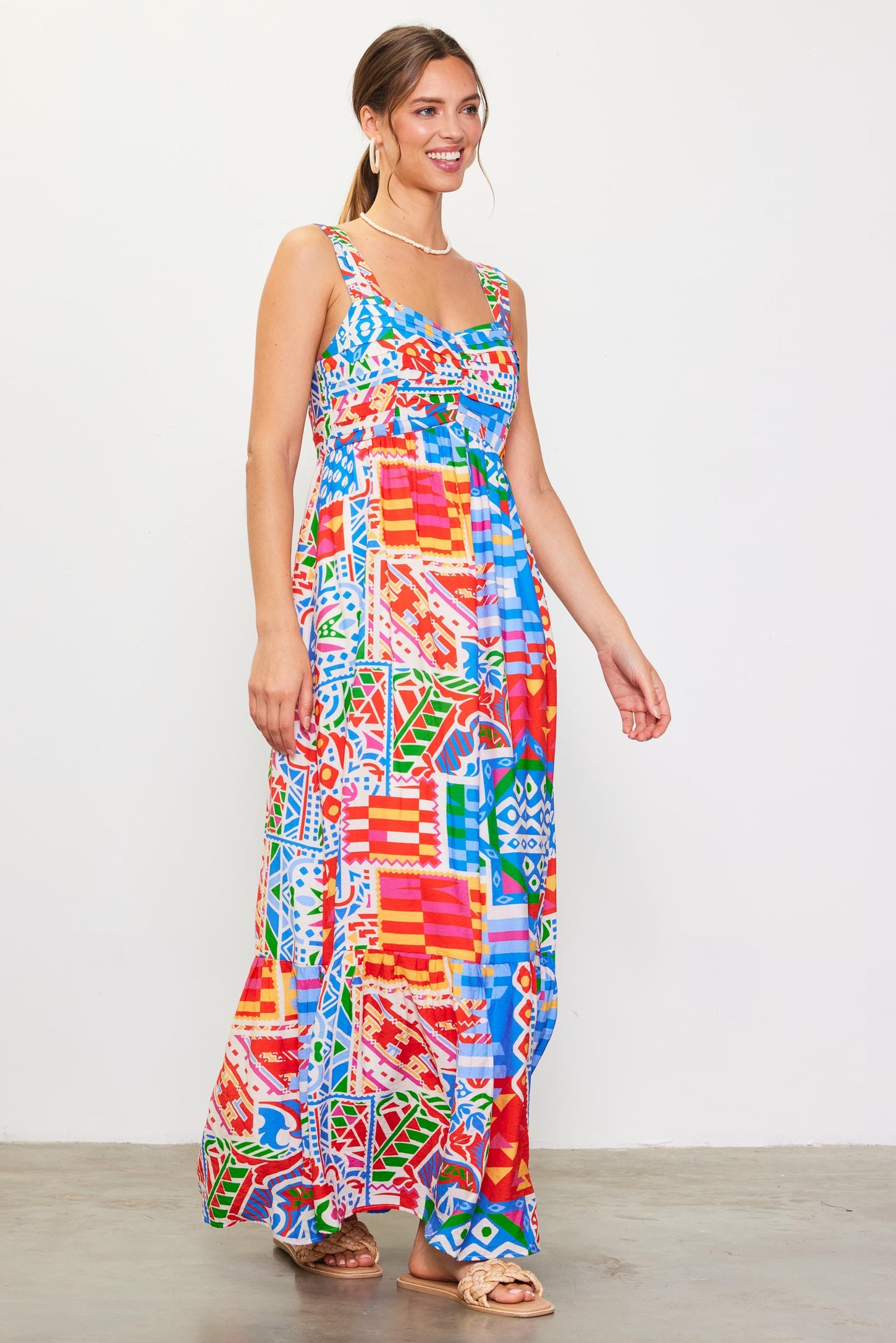 woman wearing a colorful patterned maxi dress with adjustable straps and a fitted bodice