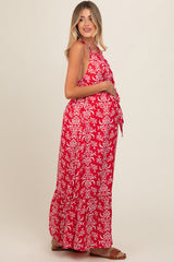 woman wearing a red floral maternity maxi dress with a halter neck and a visible baby bump