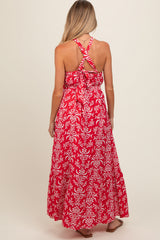 woman wearing a red floral maxi maternity dress with a crisscross back design