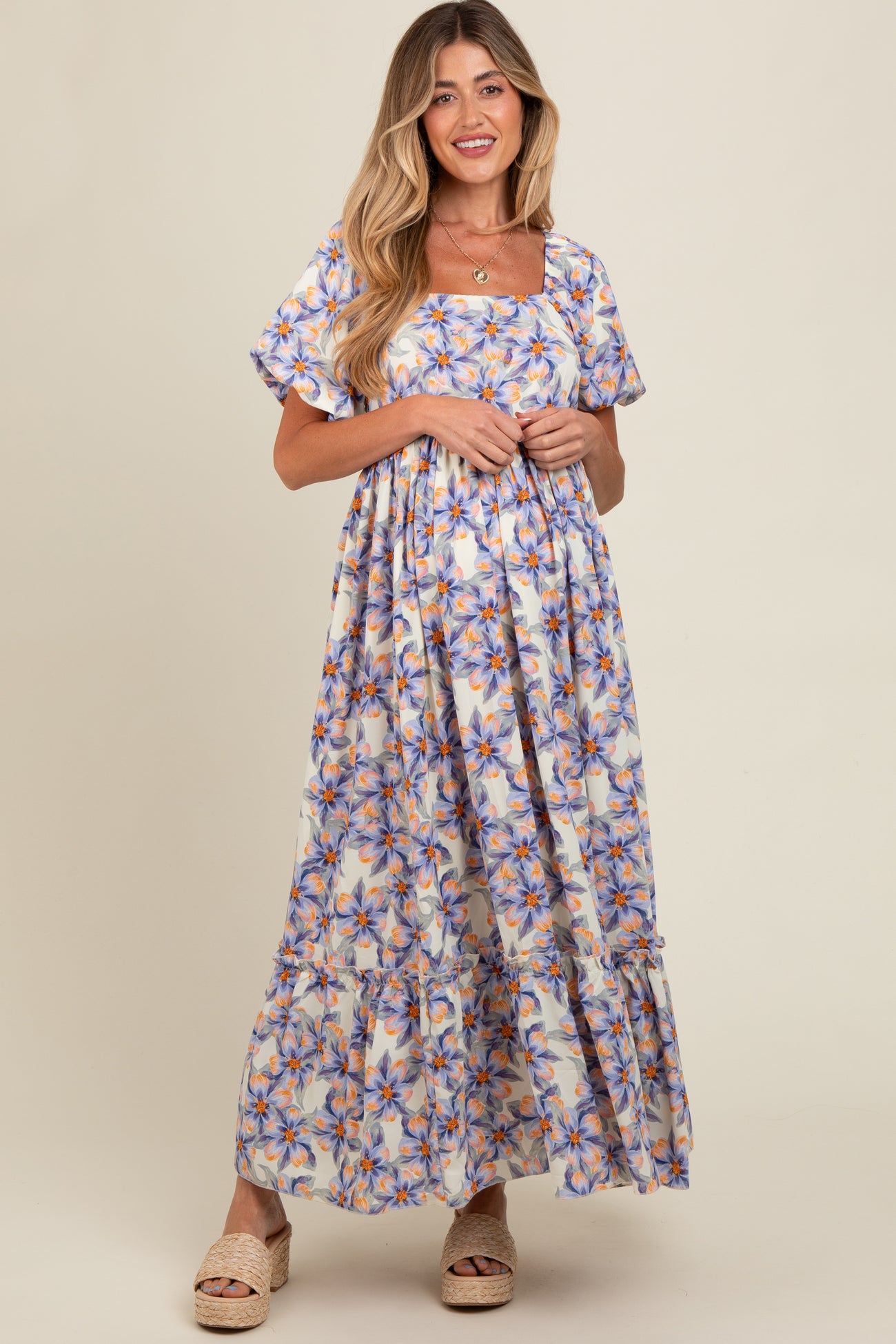 woman wearing a floral print maternity maxi dress with short sleeves and a square neckline