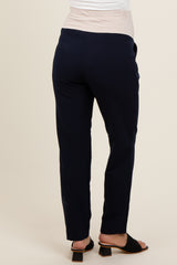 woman wearing navy maternity pants with a stretchy beige waistband, shown from the back
