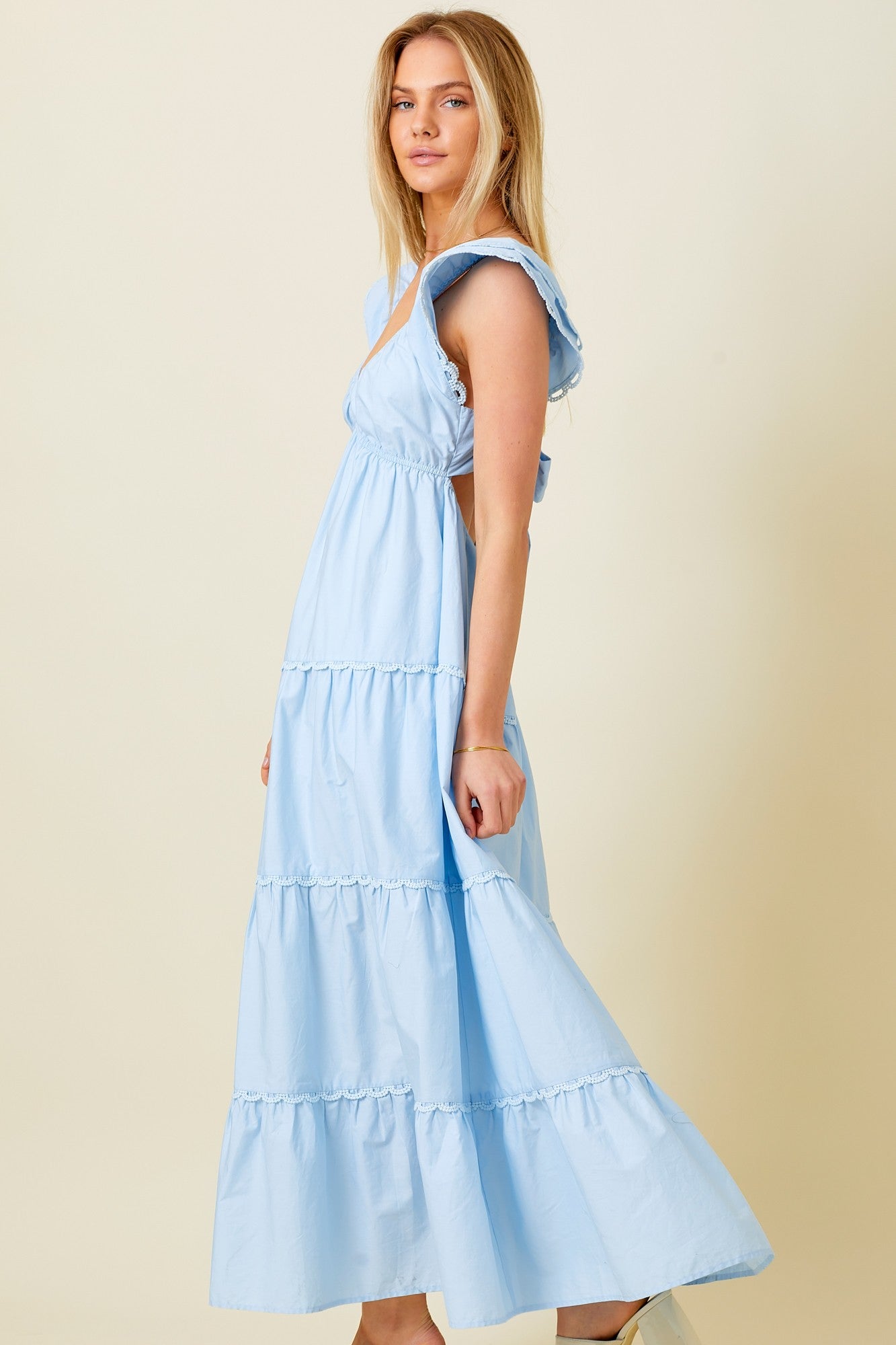 woman wearing a light blue tiered maxi dress with ruffle details and adjustable straps