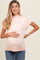 woman wearing a light pink maternity sweater with short sleeves and a visible baby bump
