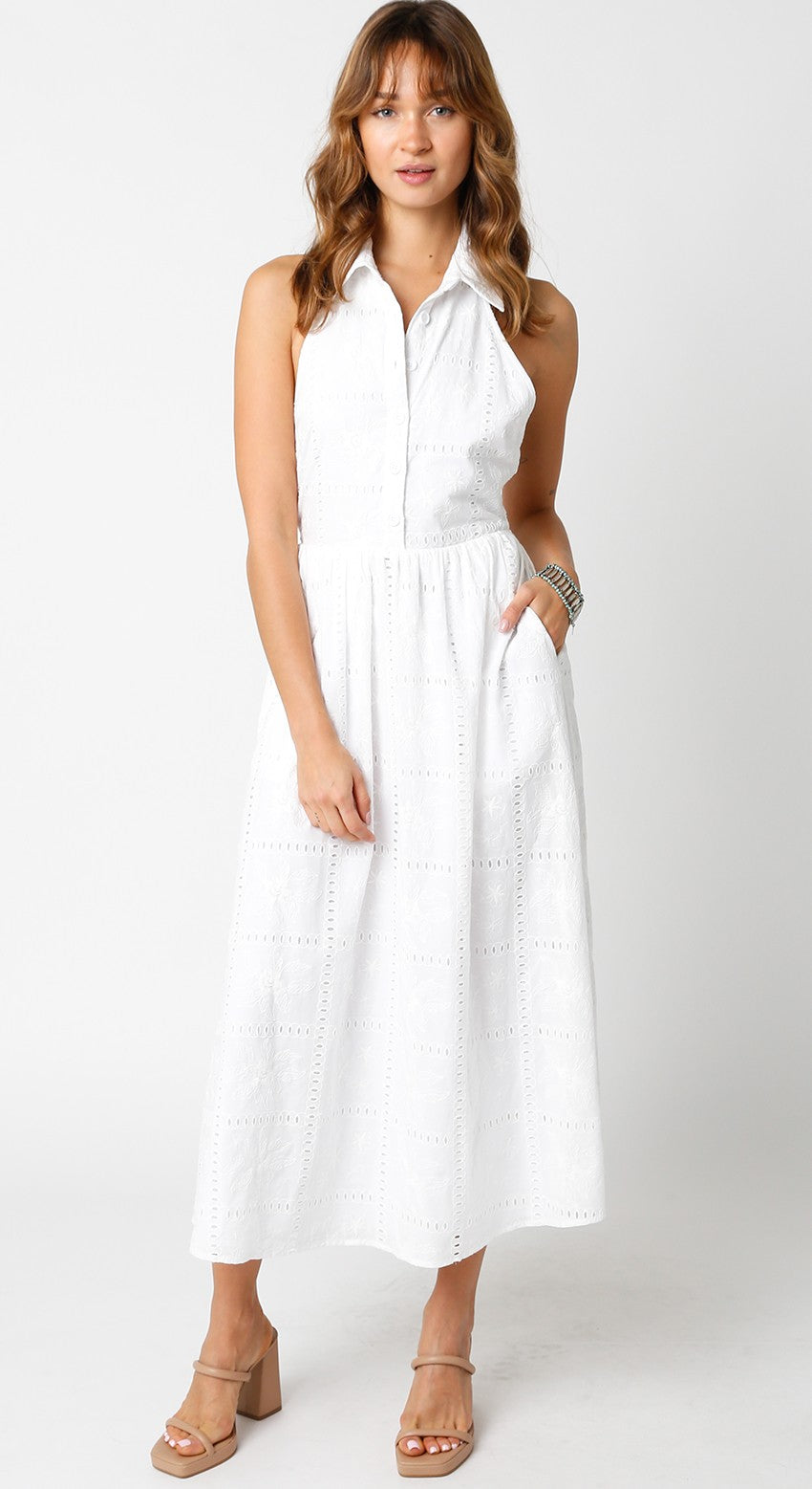 woman wearing a white sleeveless midi dress with a collared neckline and pockets