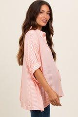 woman wearing a light pink and white striped maternity shirt with buttons and a visible baby bump