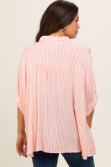 woman wearing a pink and white striped maternity top with a loose fit and rolled sleeves, showing the back view